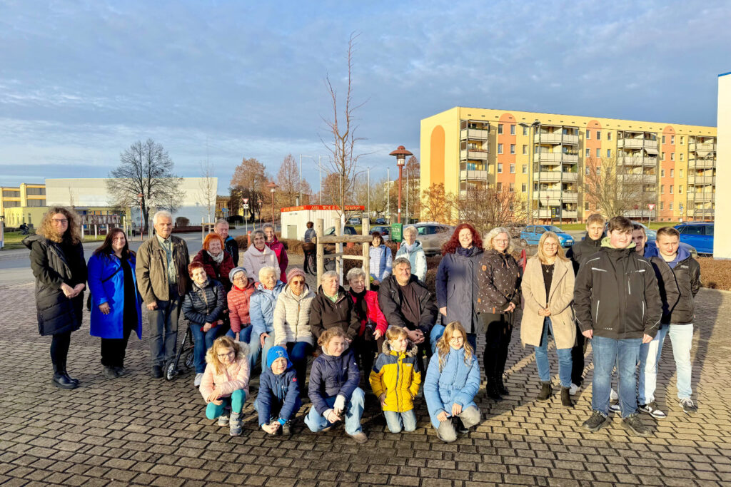 Die Übergabe der Rundbank und der Bäume an die Gemeine. Bürgermeisterin Andrea Berger (links), Netzwerkkoordinatorin Demografie und Pflege Janet Zumpe (2. v. l.), Vorsitzender der Volkssolidarität Mitgliedergruppe Nünchritz Reiner Bieder (3. v. l.)