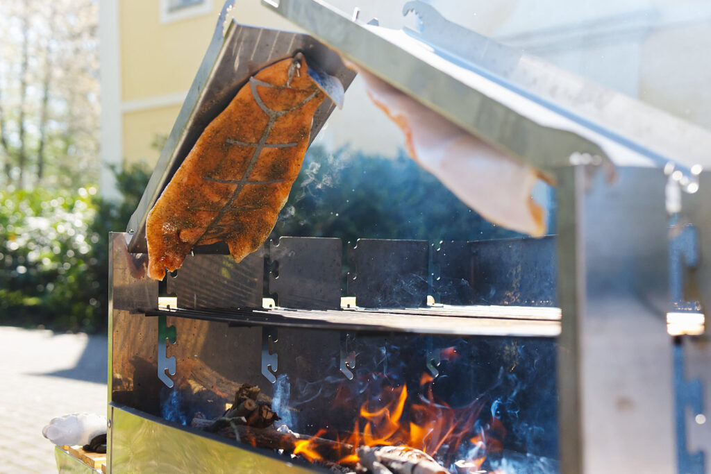 Flammlachs wird auf offenem Feuer gegrillt