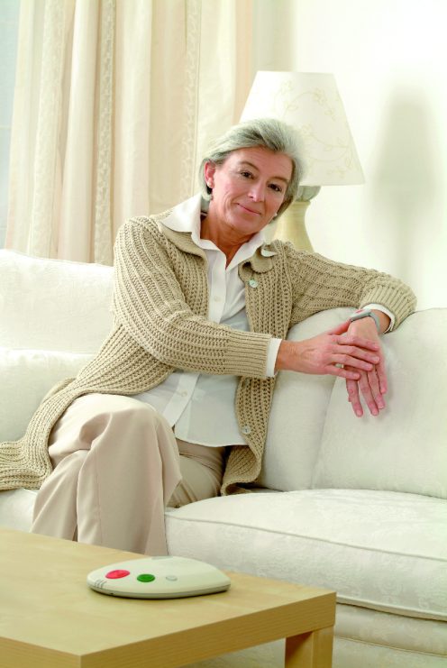 Eine Seniorin in ihrer Wohnung, ausgestattet mit dem Hautnotrufsystem.