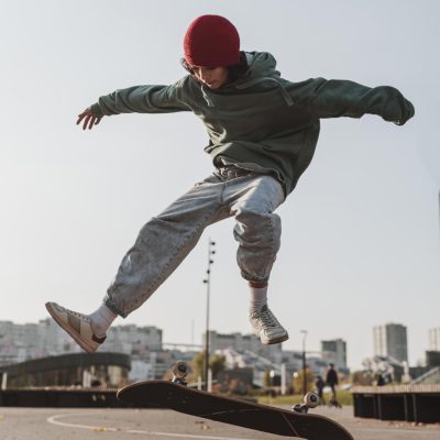 Mädchen springt mit Skateboard